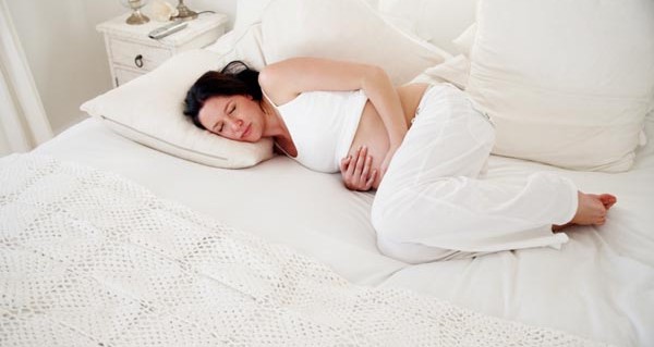 Beautiful pregnant woman sleeping in comfortable bed